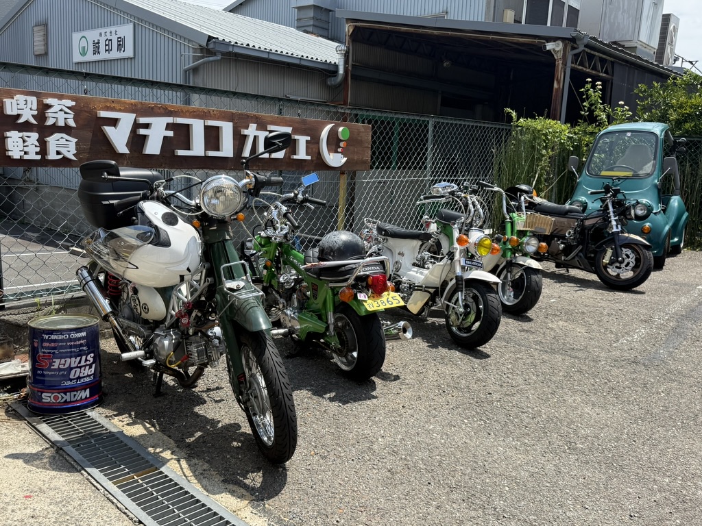 MACHICOCO CAFEの看板前に並ぶレジャーバイク（SUNDAY GARAGE）